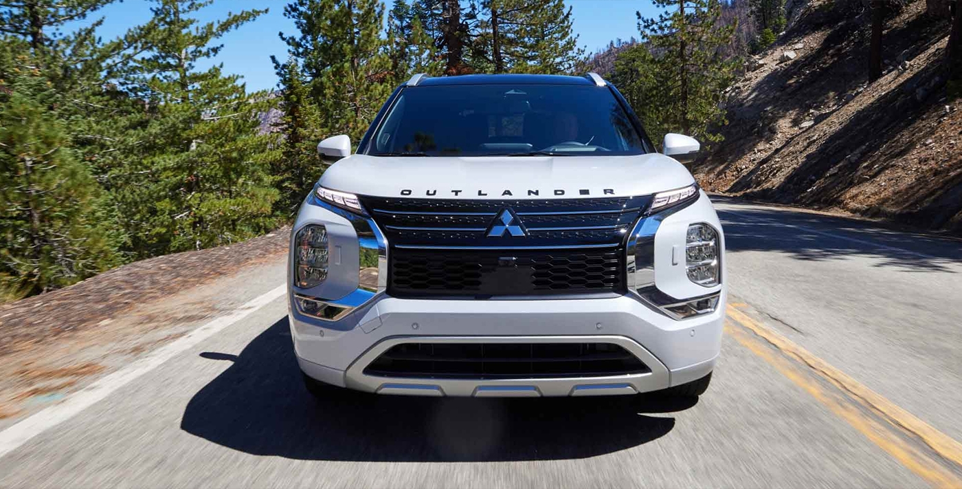 Vue avant du Mitsubishi Outlander 2026 hybride rechargeable sur route en pleine puissance..