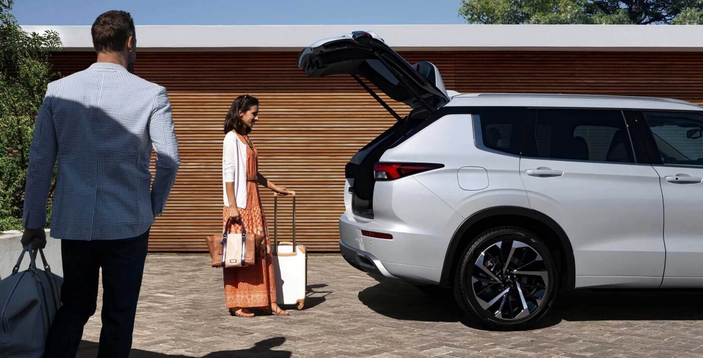 Femme chargeant le coffre du Mitsubishi Outlander 2026.