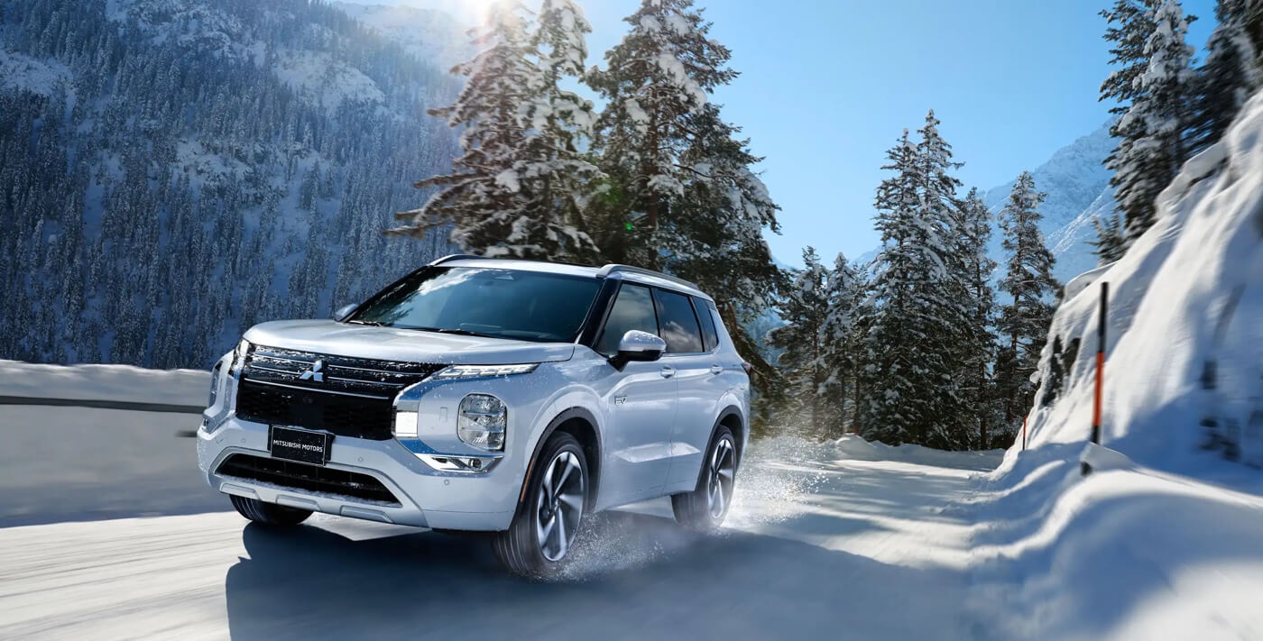 Le Mitsubishi Outlander PHEV 2024 qui monte une côte en hiver.