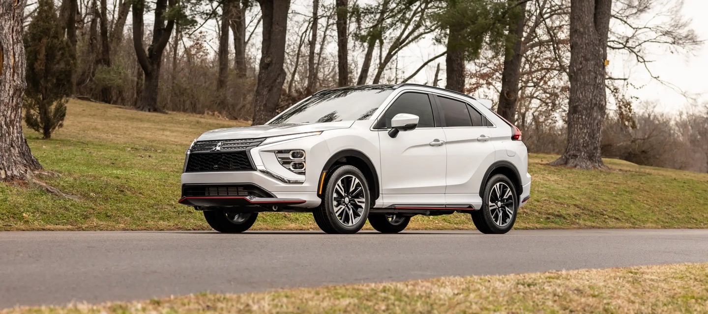 Le Mitsubishi Eclipse Cross stationné sur une route dans les bois.